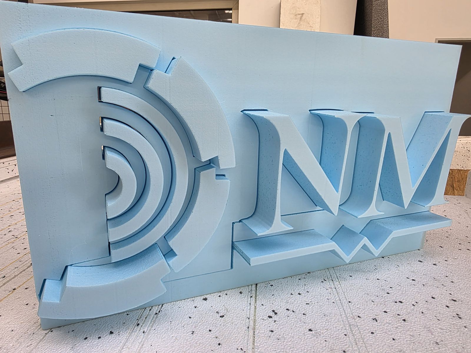 DnM-Logo dreidimensional aus hellblauem XPS-Hartschaum gefräst